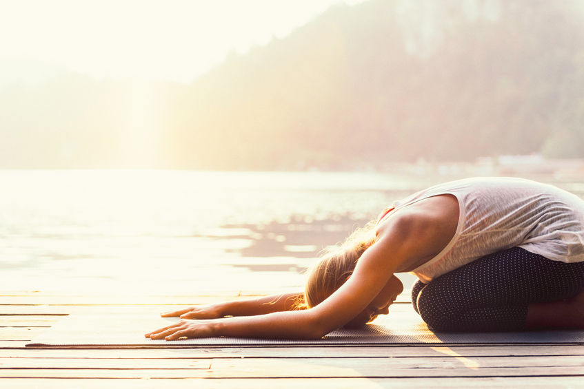 mujer practicando postura de yoga balasana